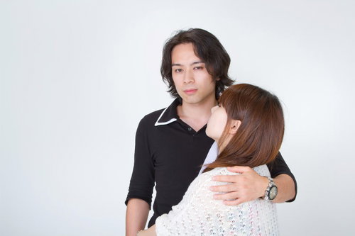 後ろから彼女の肩をそっと抱きしめる男性の横顔