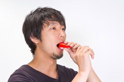 パーティー用クラッカーを口にくわえてパフォーマンスする男性