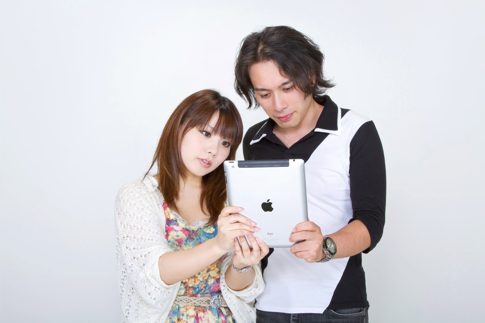 男女2人がiPadを一緒に見ているカップル［モデル：マイケルリュー Lala］