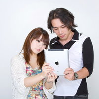 仲良くiPadを見る恋人の写真