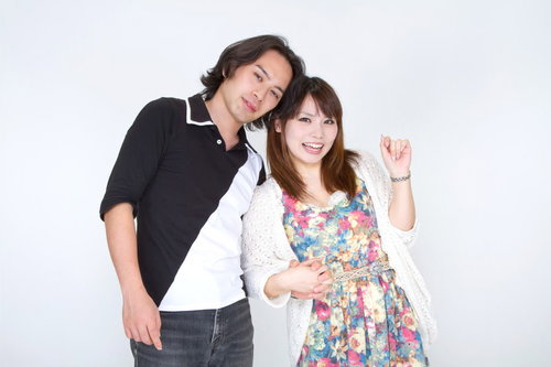 指を絡ませて手を握り合う若いカップルの手元