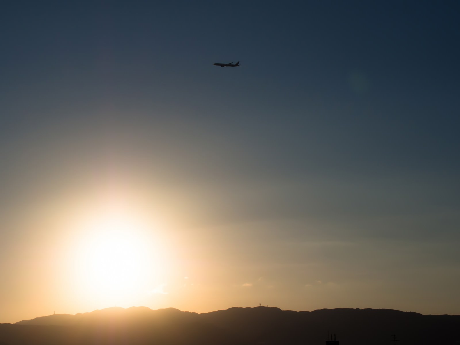 夕焼けの空を横切る飛行機