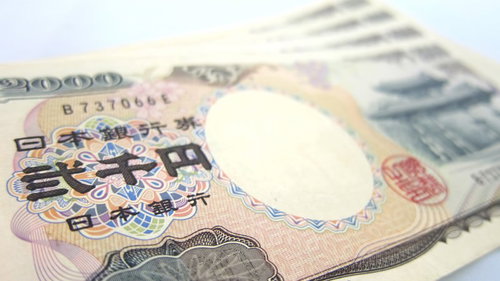 白い台に重ねた２千円札と一万円札