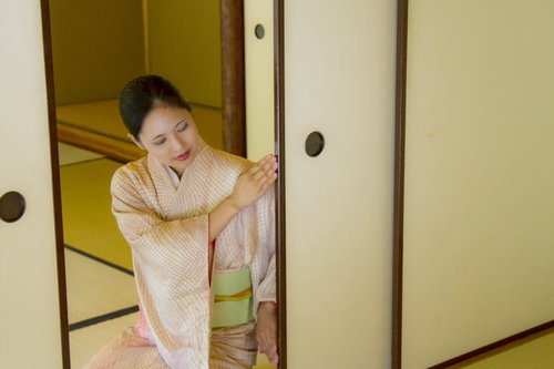 和室のふすまを開ける着物の女性