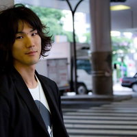 窓のある部屋で壁に寄り掛かる若者の写真