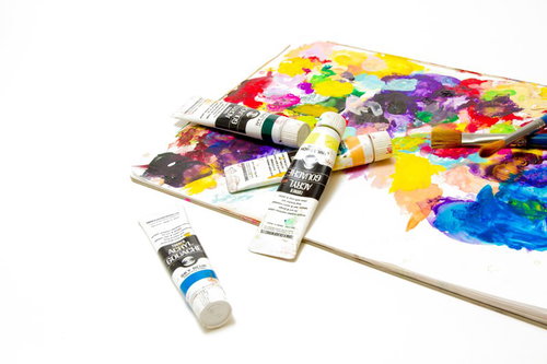 カラフルな絵の具が出された木のパレットと筆