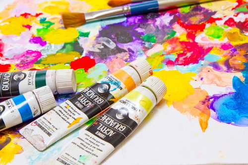 木のパレットの上にチューブから出した絵の具が散らばるアート風景