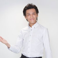 手を差し出してお客様をご案内するウェイターの男性の写真