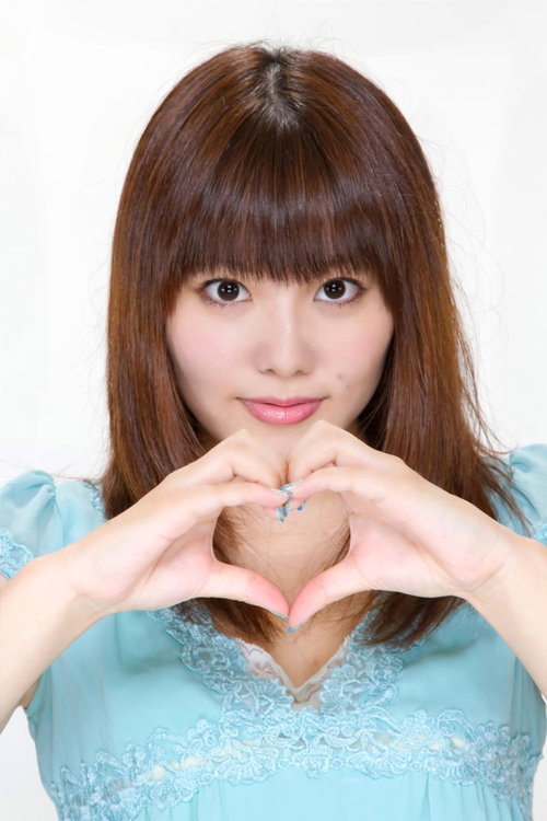両手の指でハートマークの形を作る笑顔の女性
