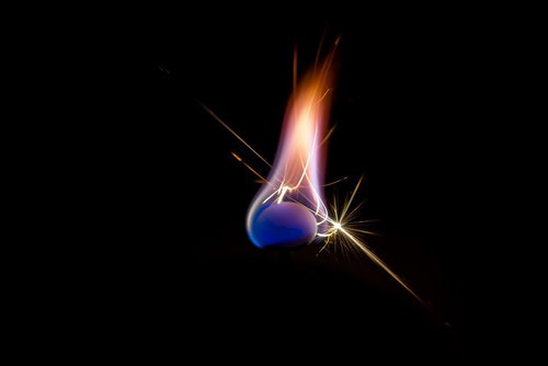 暗闇の中で赤い火花を散らして燃える線香花火の先端