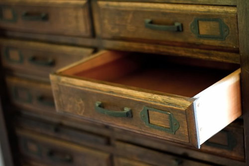 木目が見える引き出しが開いた古びたタンスの正面