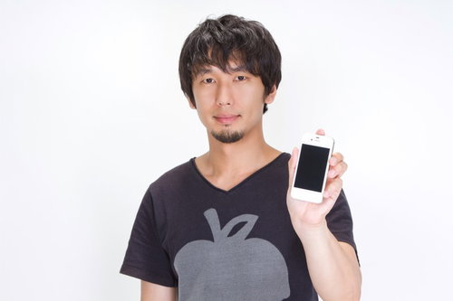 スマートフォンの画面を正面に向けて見せる男性