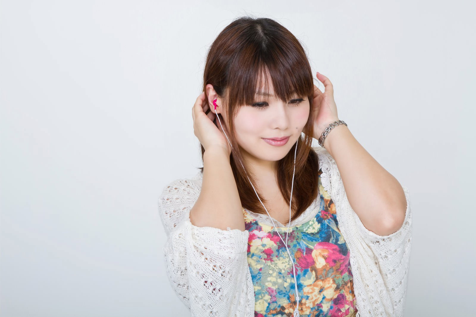 目を閉じてイヤホンで聴く女性［モデル：Lala］