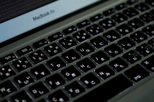 暗い部屋でバックライトが光るMacBook Airのキーボード