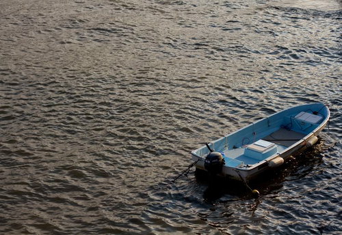 穏やかな水面に浮かぶ波に揺られる小さなボート