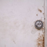 赤茶色に錆びた扉と古い鉄のドアノブの接写の写真