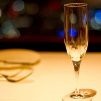 白いテーブルに置かれた泡が立つシャンパングラスの写真