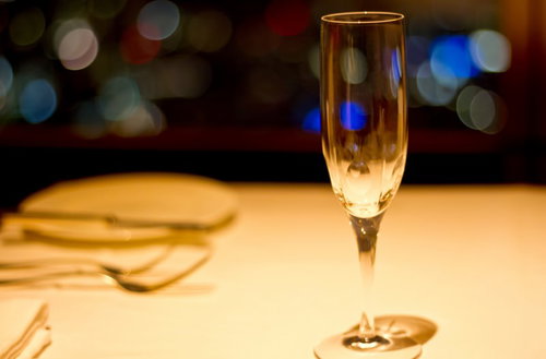 白いテーブルに置かれた泡が立つシャンパングラス