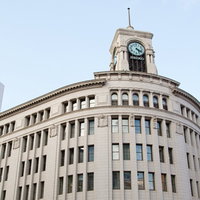 SEIKOの時計塔がある白い石造りのビルの写真