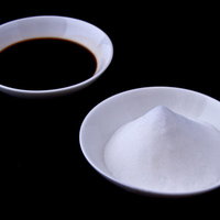 木の板の上に並ぶ白い塩の山と茶色い醤油の写真