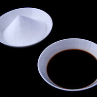 ガラスの醤油差しと白い小皿の塩が並ぶ調味料の写真