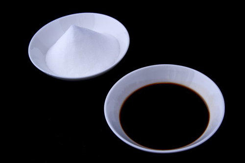 ガラスの醤油差しと白い小皿の塩が並ぶ調味料