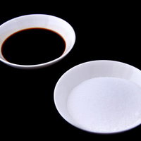 白いお皿に分けて盛られた白い塩と茶色い醤油の写真
