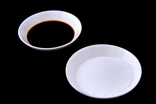 白いお皿に分けて盛られた白い塩と茶色い醤油