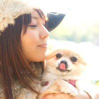 暖かい日差しの中で舌を出してペロリとする犬と飼い主の写真