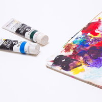 使い込まれて色が混ざった汚れた絵の具のパレットの写真