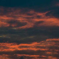 ピンクとオレンジに染まる夕暮れの空に浮かぶ雲の写真