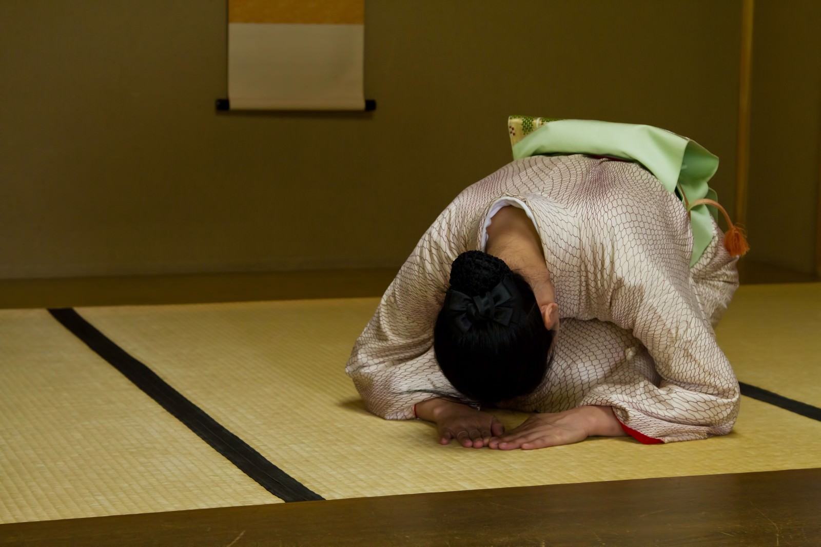 和室で深々と頭を下げ礼をする着物の女将［モデル：きせんひろみ］