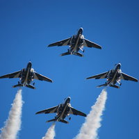 青空を飛ぶブルーインパルス（T-4）の編隊飛行の写真