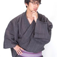 考え事をして髭を触る浴衣メガネ男子の写真