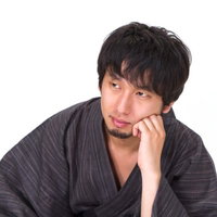 肘を立てて考え込む浴衣の男性のポーズの写真