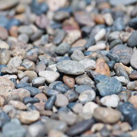 色が混ざる河川の丸い小石の写真