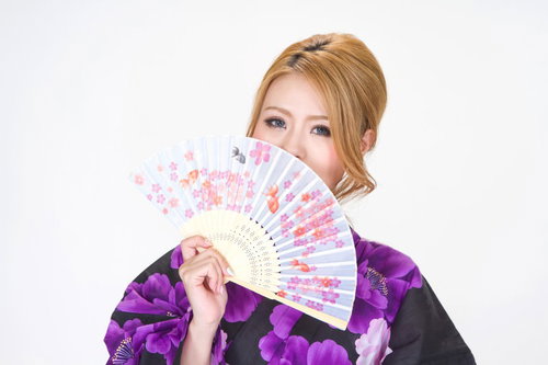金魚柄の扇子を広げる浴衣の女性