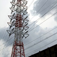 鉄塔と電線が交差する曇り空と送電線の風景の写真
