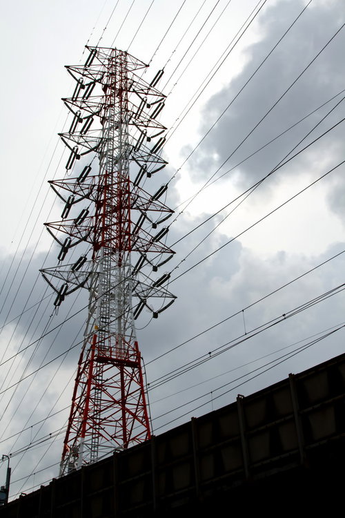 鉄塔と電線が交差する曇り空と送電線の風景