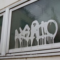 建物の窓に垂れた白いペンキの落書きの写真