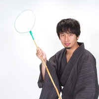虫あみを構えてカメラを見る浴衣男子の写真