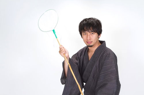 虫あみを構えてカメラを見る浴衣男子