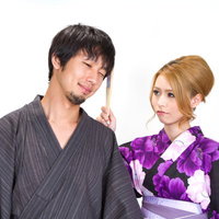 扇子で恋人をペシッと叩く浴衣の女性の写真