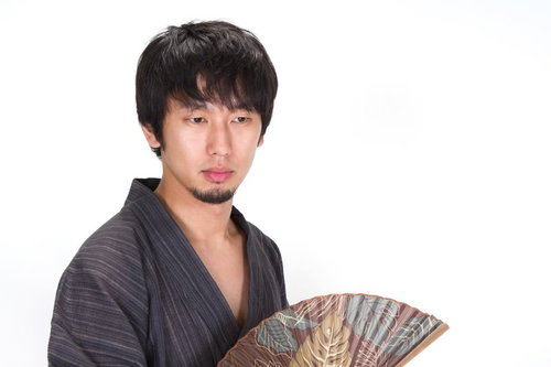 扇子を持ち虚ろげな表情の浴衣の男性