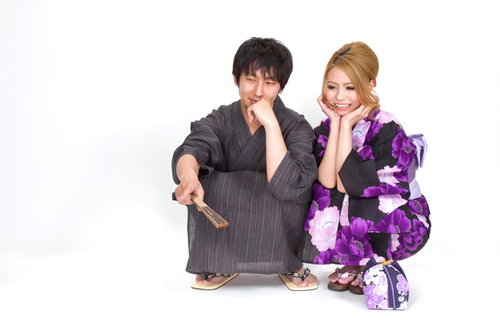 しゃがみこみ指をさす浴衣の恋人カップル