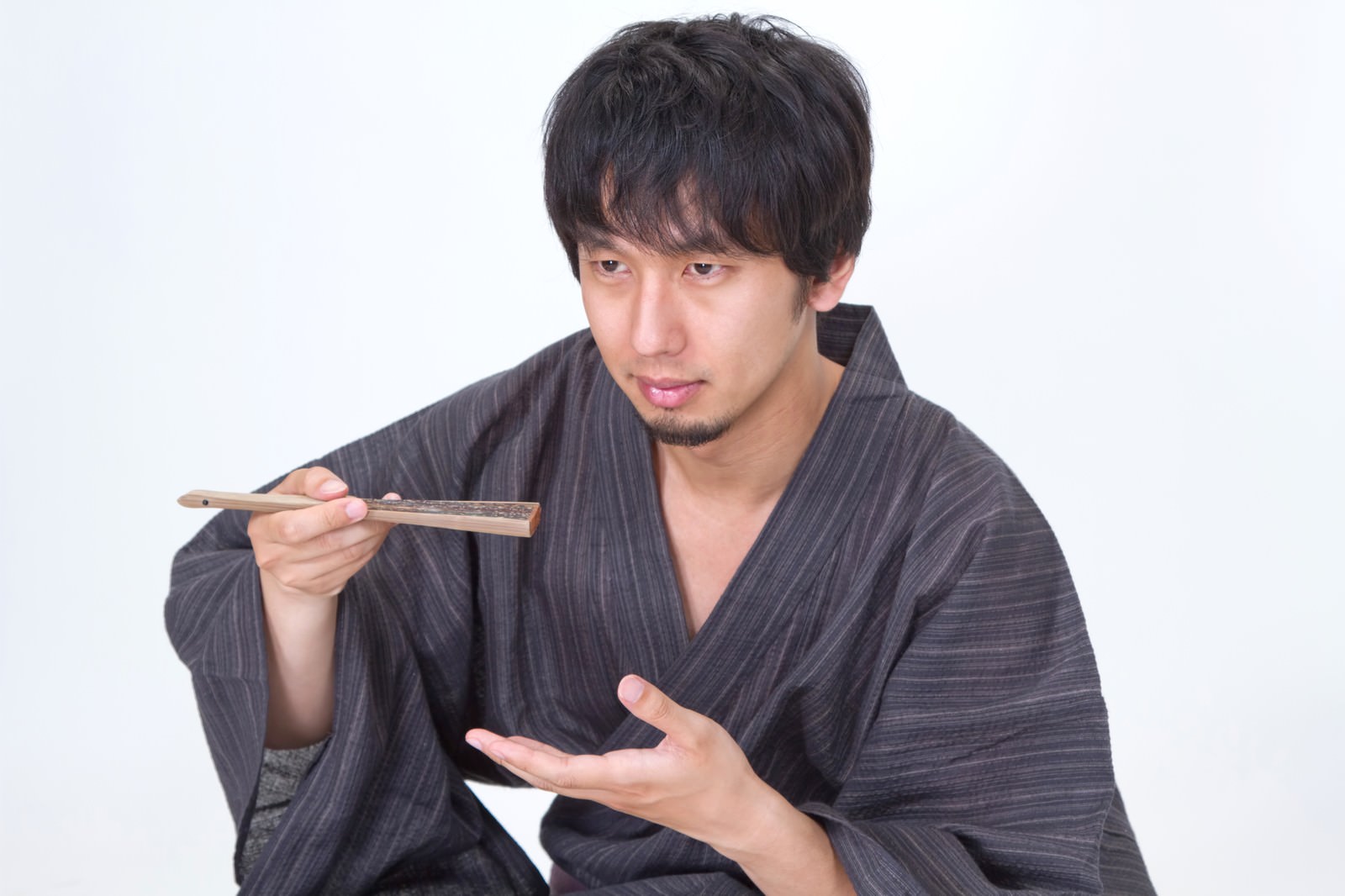 扇子を使って何かを食べる浴衣男子のポーズ［モデル：大川竜弥］