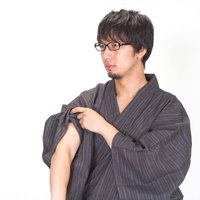 片肌見せて腕まくりをする眼鏡浴衣男子の写真
