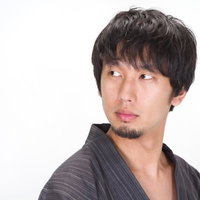 後ろを振り返る浴衣を着た髭男子の写真