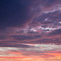 グラデーションに染まる夕焼け色の空と雲の写真