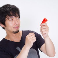 クラッカーを両手に構えて「おめでとうございます」と祝福する男性の写真